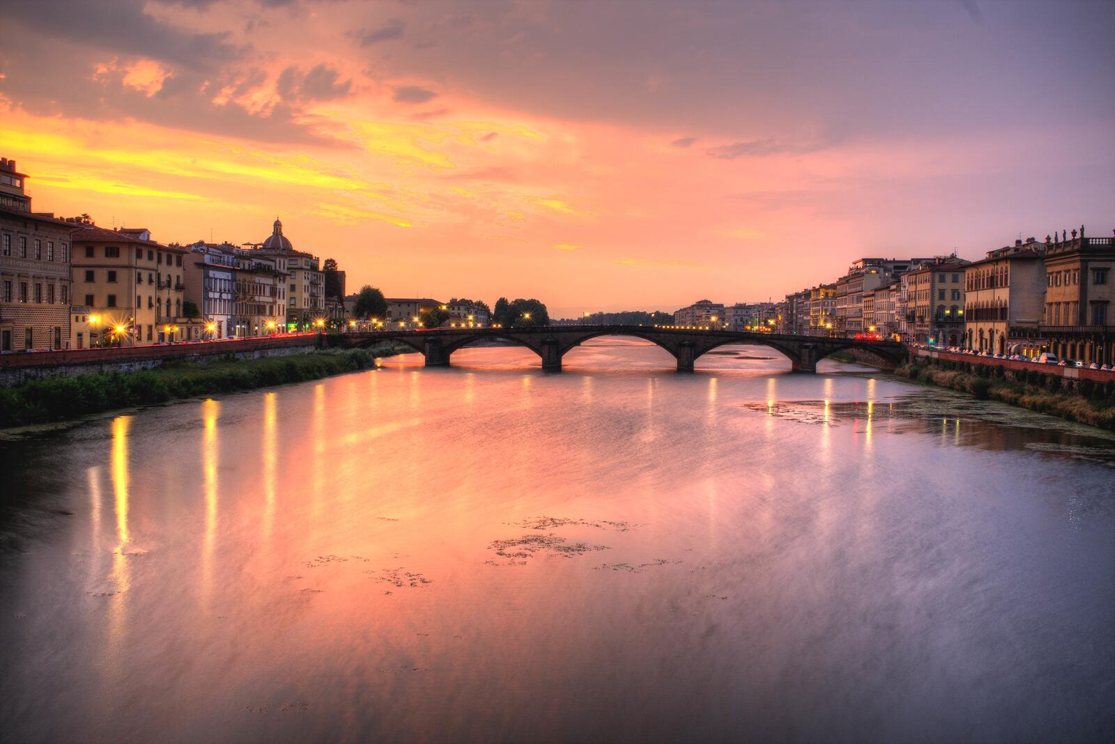 Бесплатное фото Мост через реку в городе на закате
