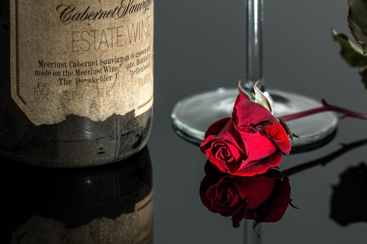 A red rose lies on a glass surface