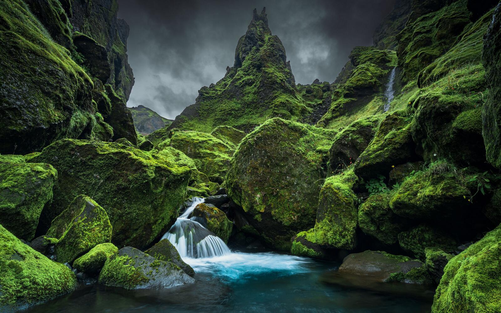 Бесплатное фото Водопад среди больших камней покрытых мхом