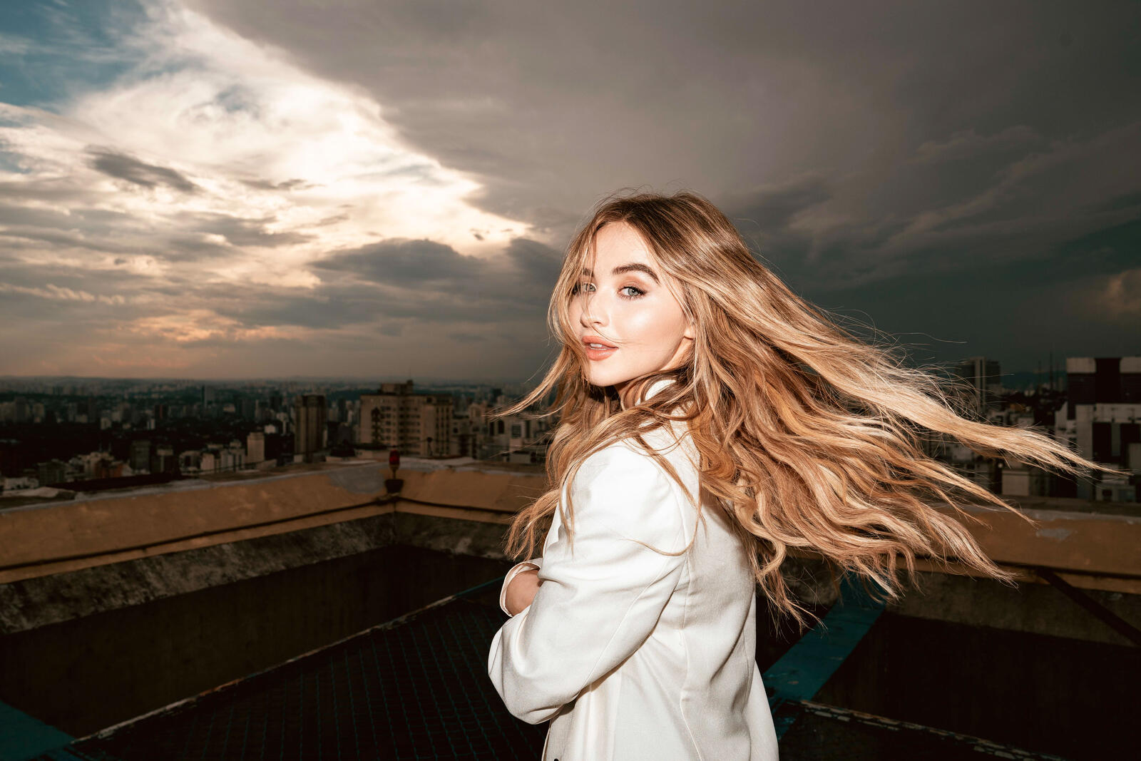Free photo Sabrina Carpenter on the background of the evening city