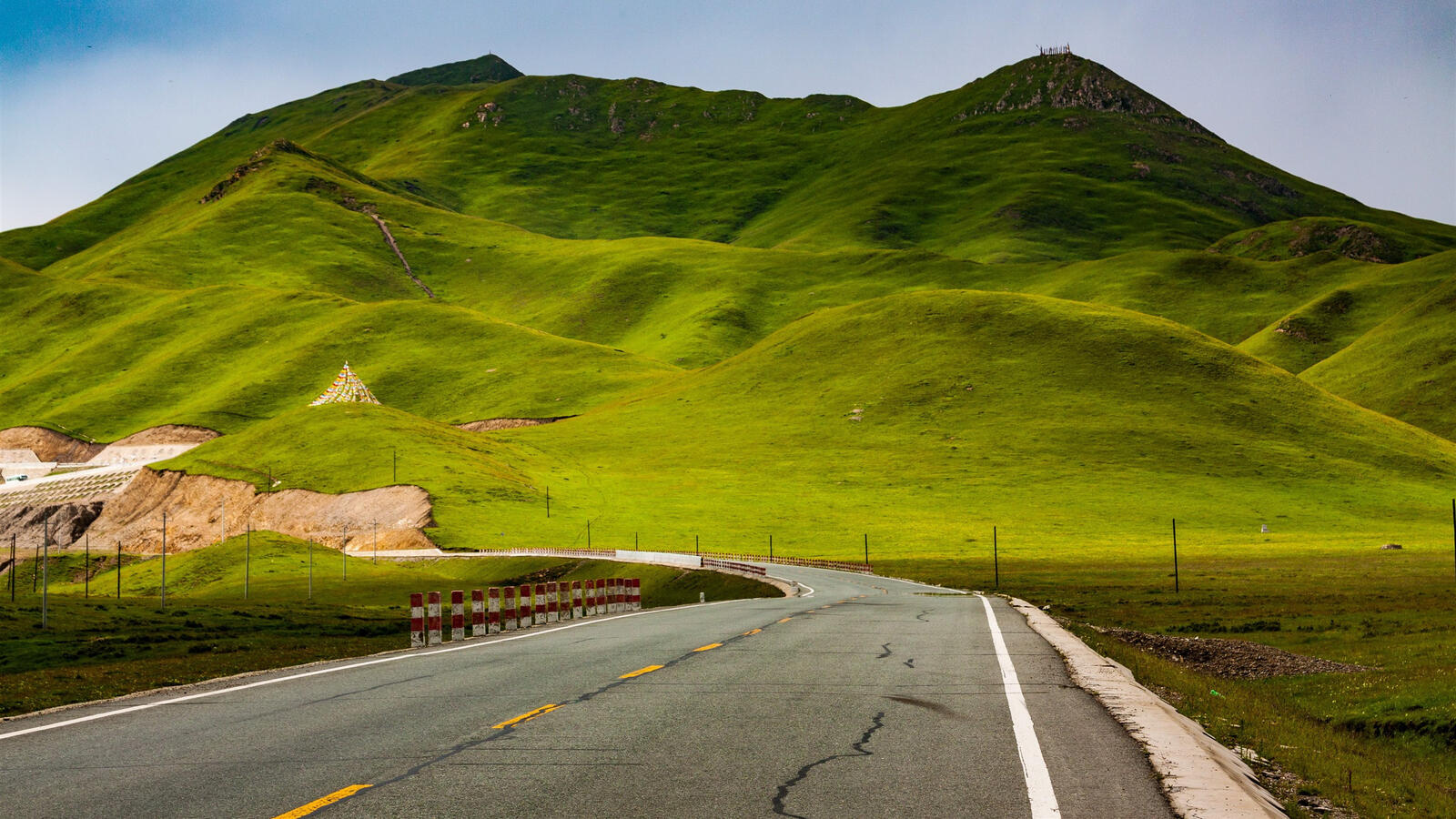 Бесплатное фото Картинка с асфальтированной дорогой у зеленых холмов
