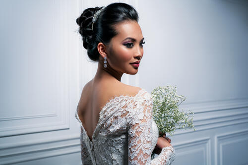 Asian model in a nude shoulder-length wedding dress