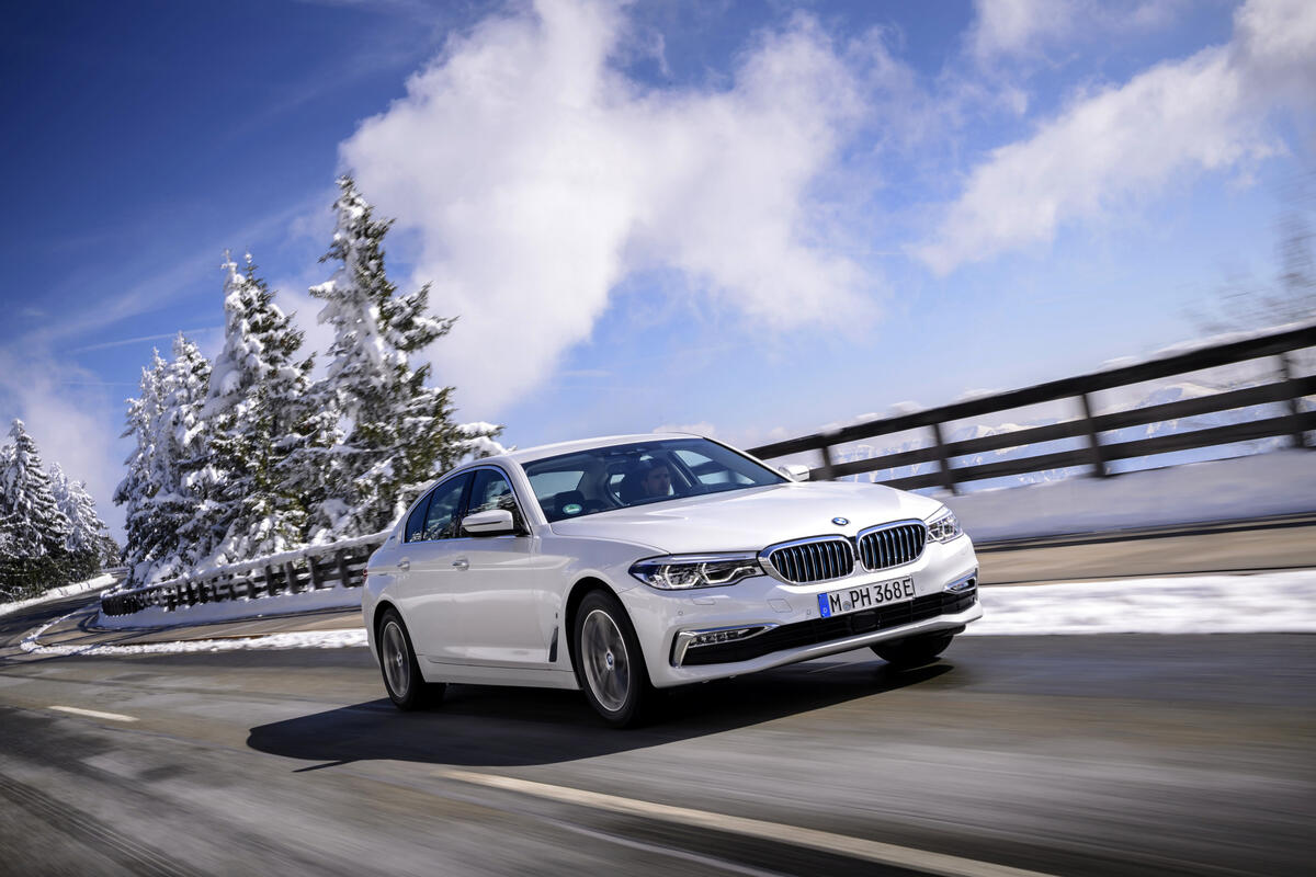 A white BMW 5 in motion