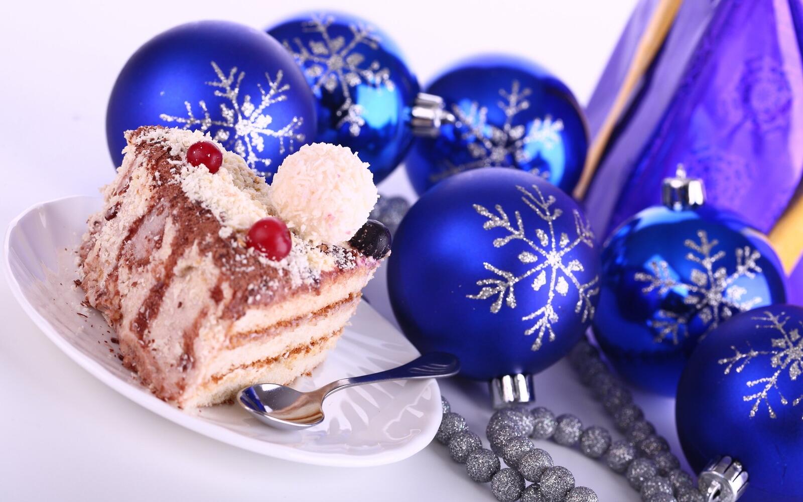 Free photo Cake next to Christmas balls in blue