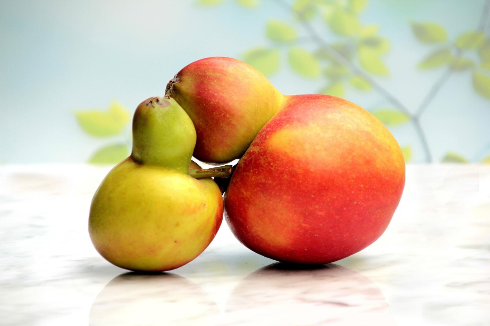 免费照片两个苹果和一个梨子交叉在一起
