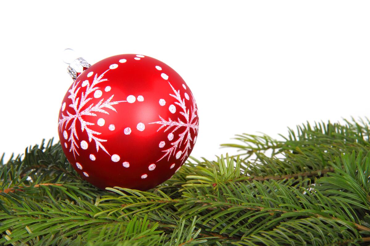 A red ball on the Christmas tree with a snowflake painted on it