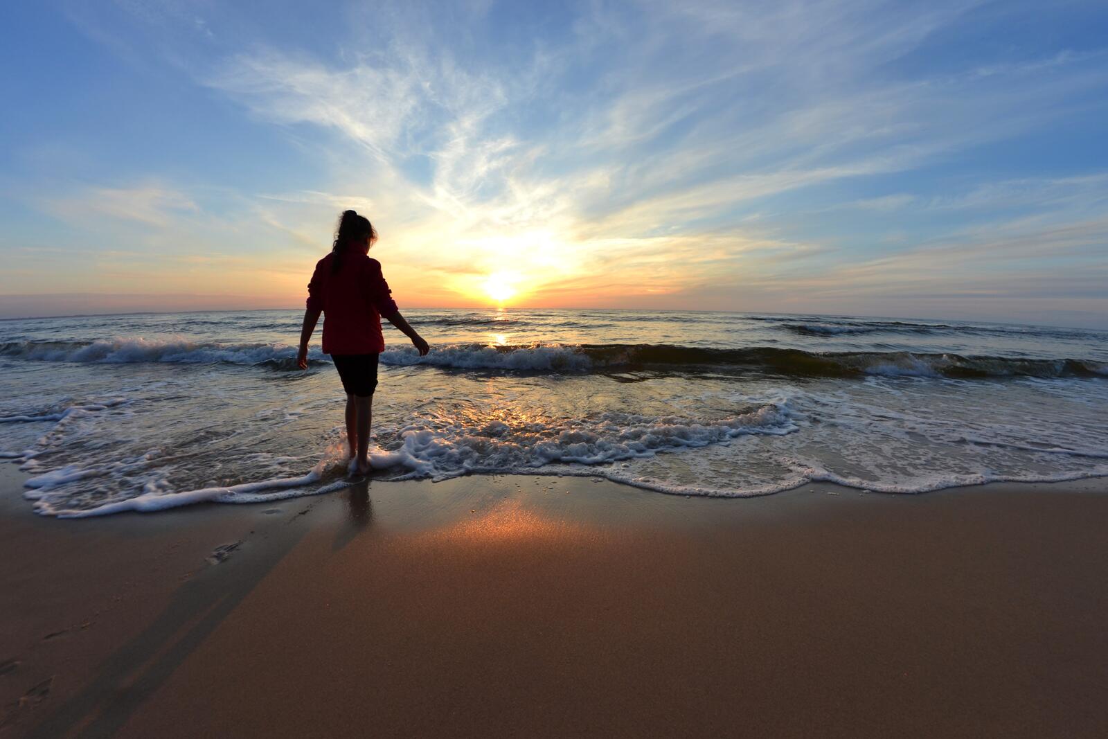 Девушка на берегу моря во время заката