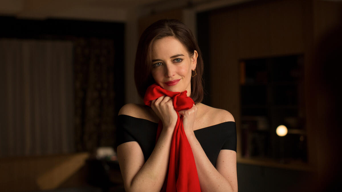 Eva Green in black dress embraces red fabric
