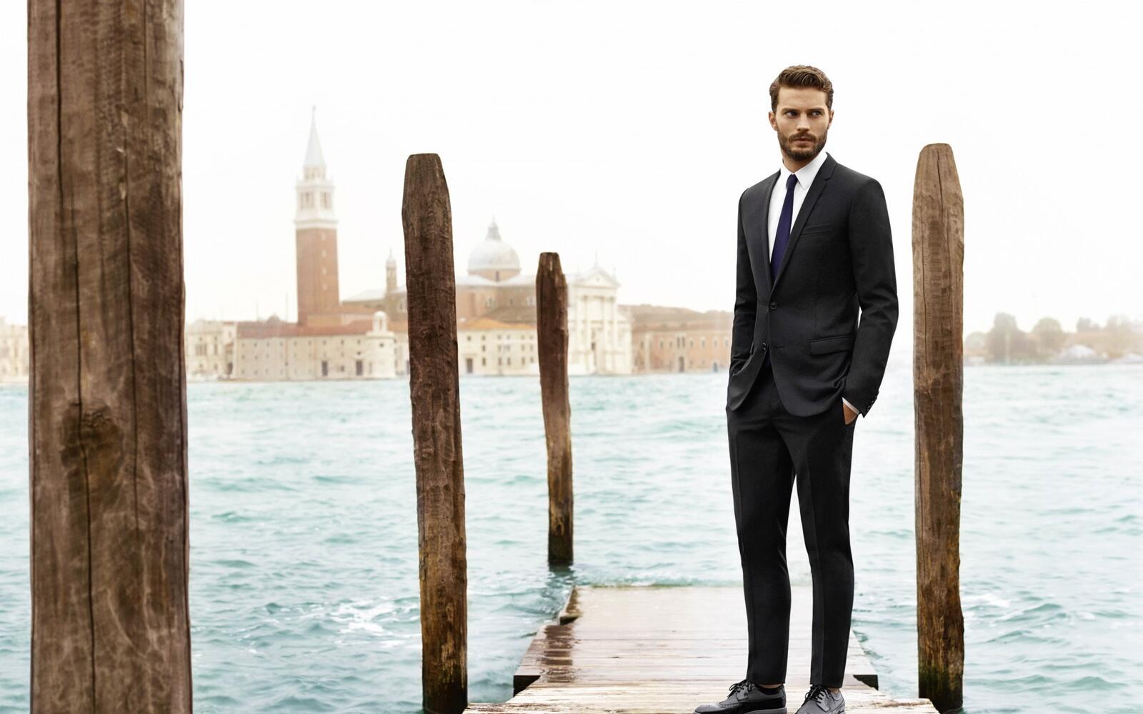 Free photo Jamie Dornan in a tuxedo standing by the water.