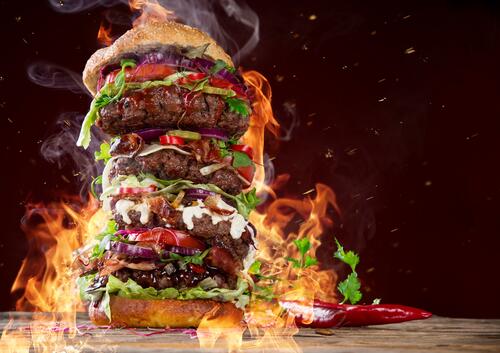 A very large hamburger on fire
