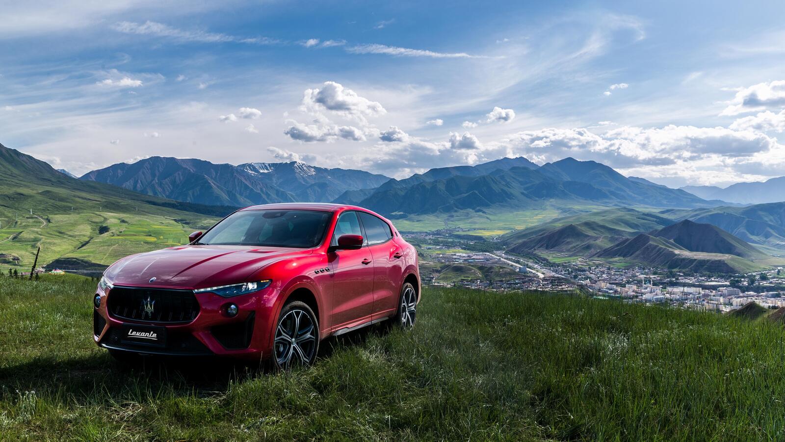 Free photo A red Maserati levante against the mountains.