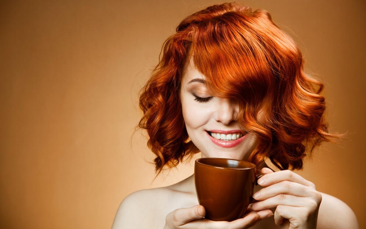 Рыжеволосая девушка с чашкой кофе