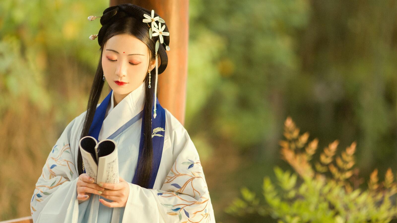 Бесплатное фото Японская девушка в кимоно читает книгу