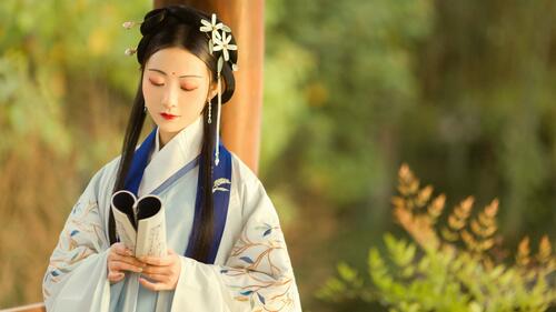 Japanese girl in kimono reading a book.