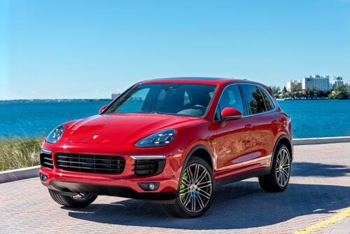 A red Porsche Cayenne against the backdrop of the sea