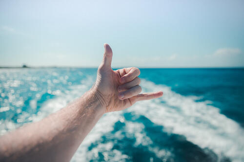 A hand gesture against the sea