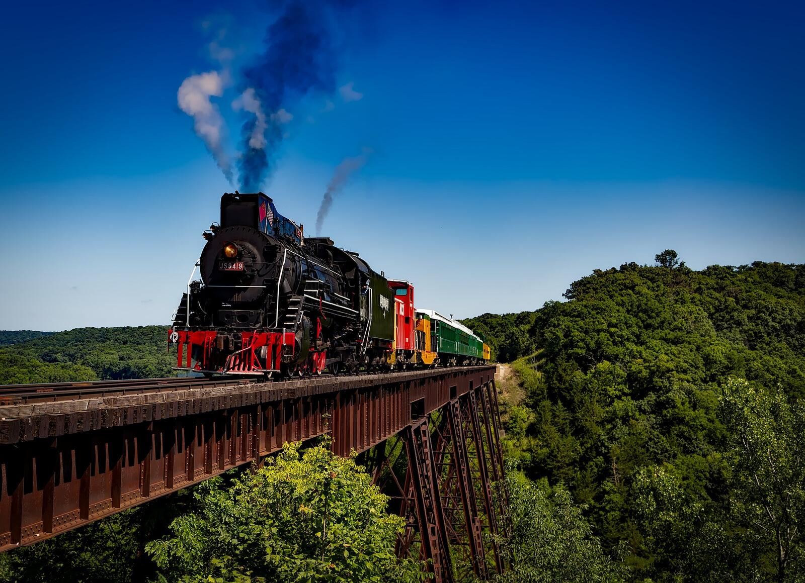 Free photo A steam locomotive on an ancient iron bridge