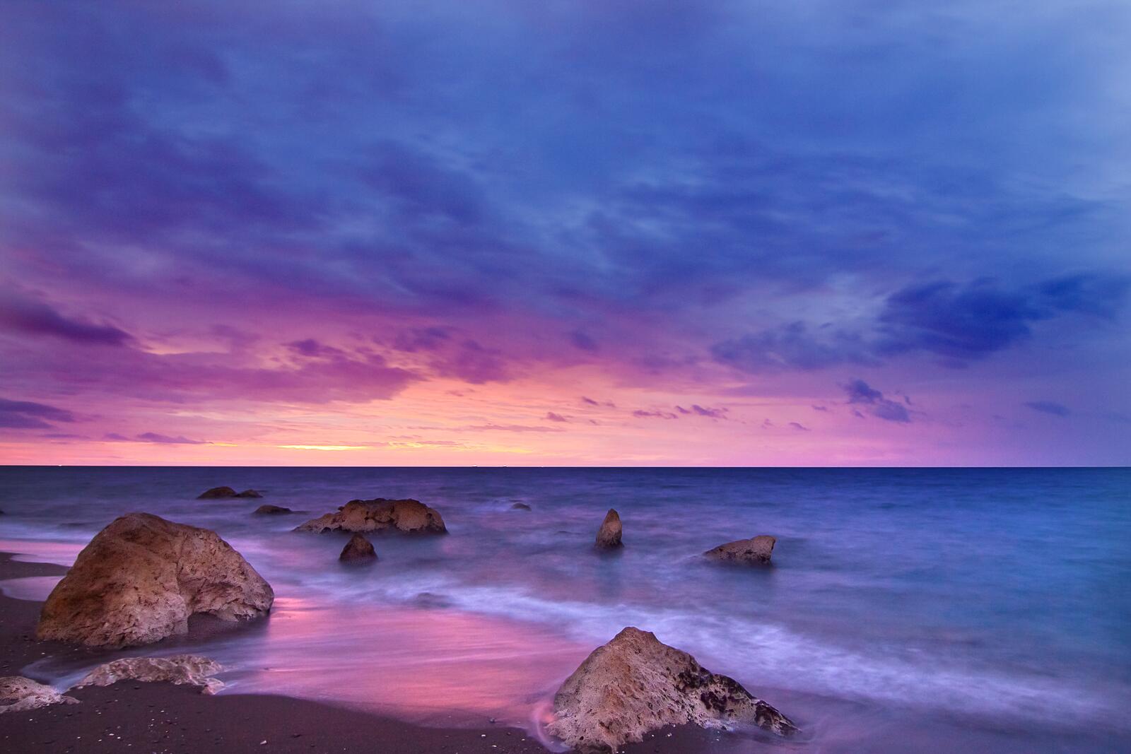 Бесплатное фото Поздний закат над морем с синима облаками