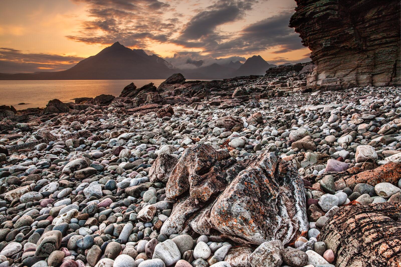 Бесплатное фото Каменистый берег моря с горой вдали