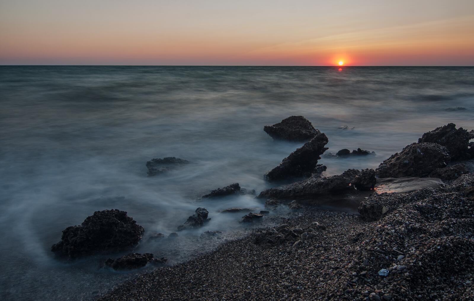 Бесплатное фото Пляж из маленьких камней на закате