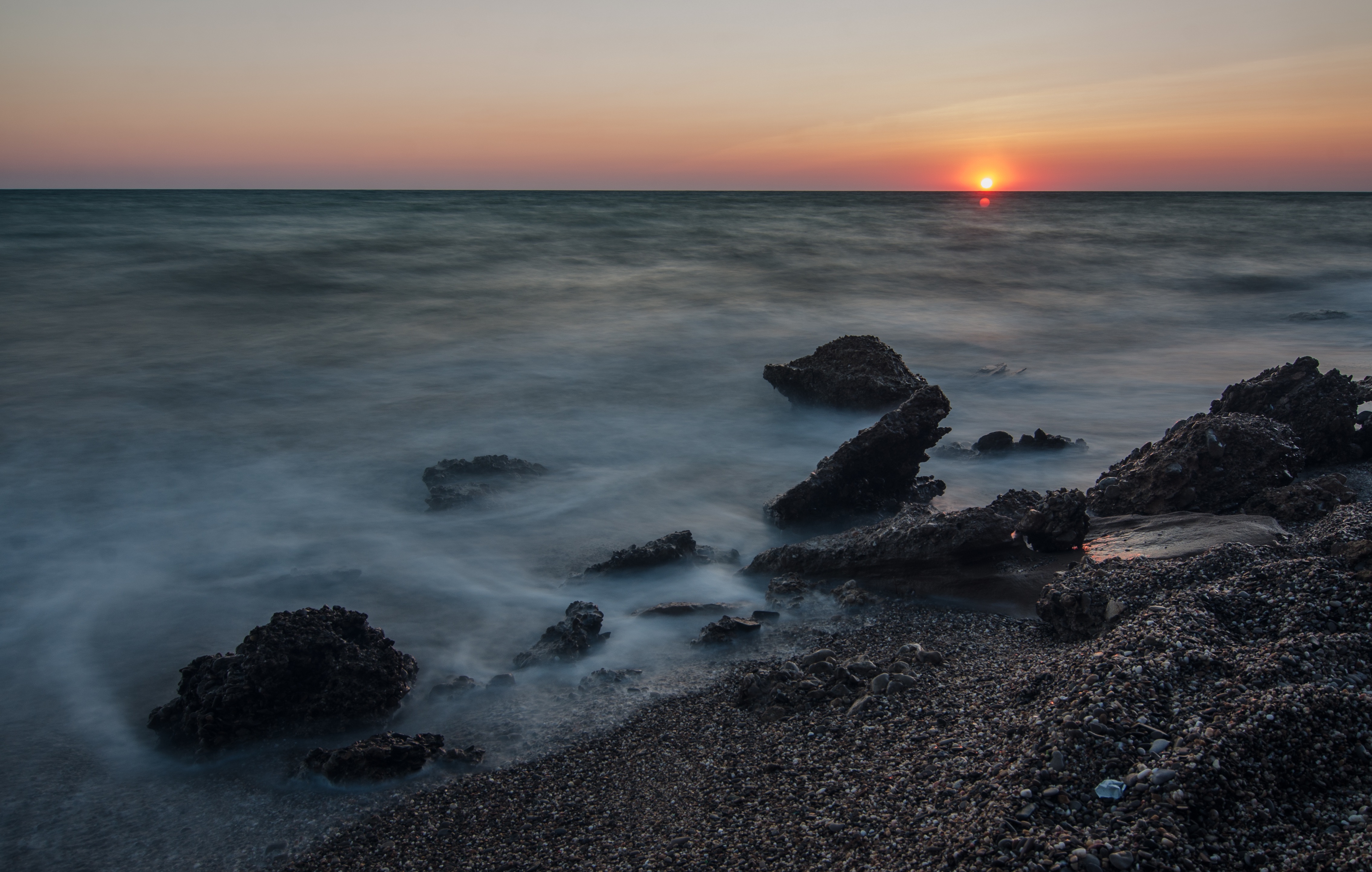 免费照片夕阳下的小石滩