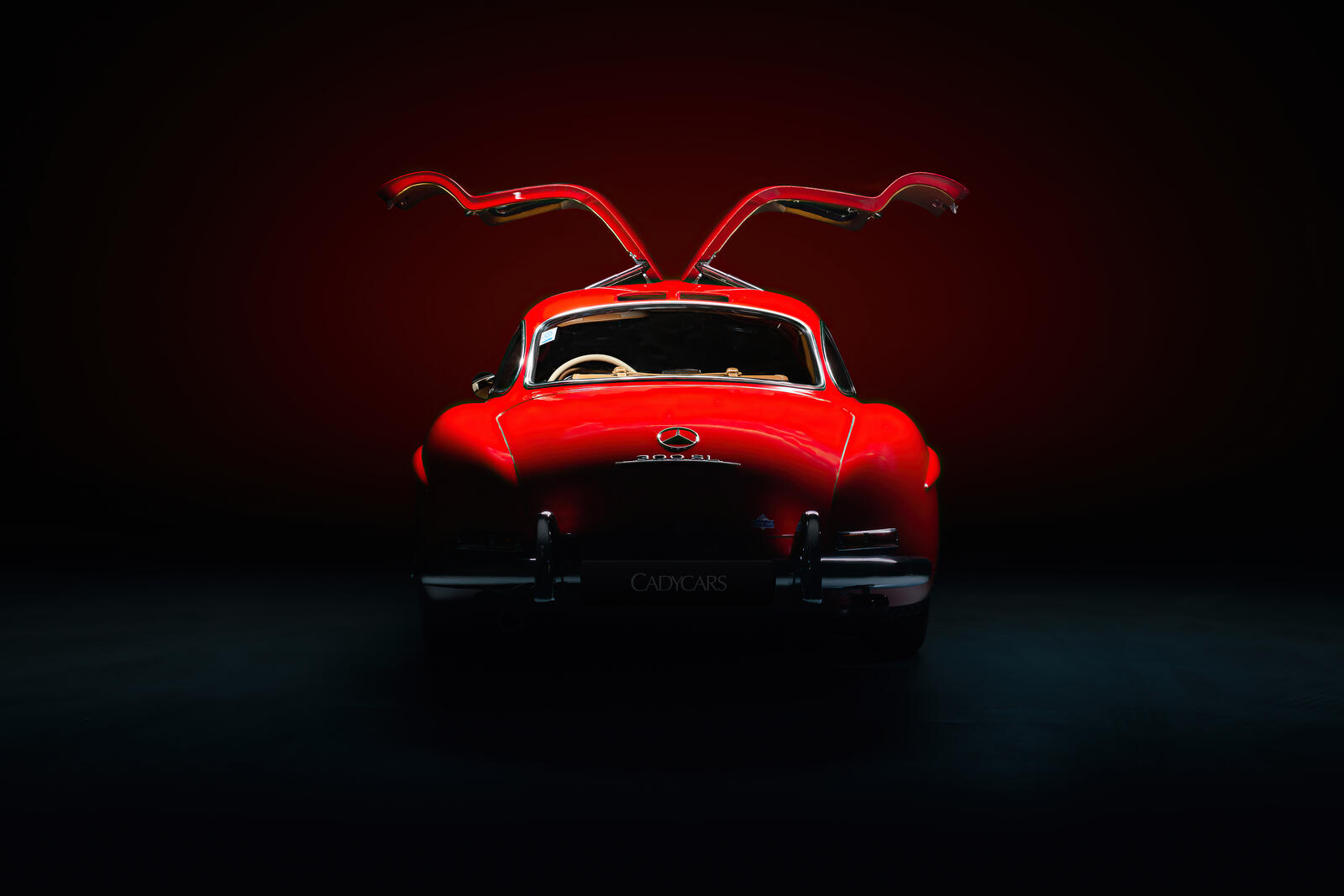 Бесплатное фото Красный mercedes benz 300sl в темноте с открытыми дверями