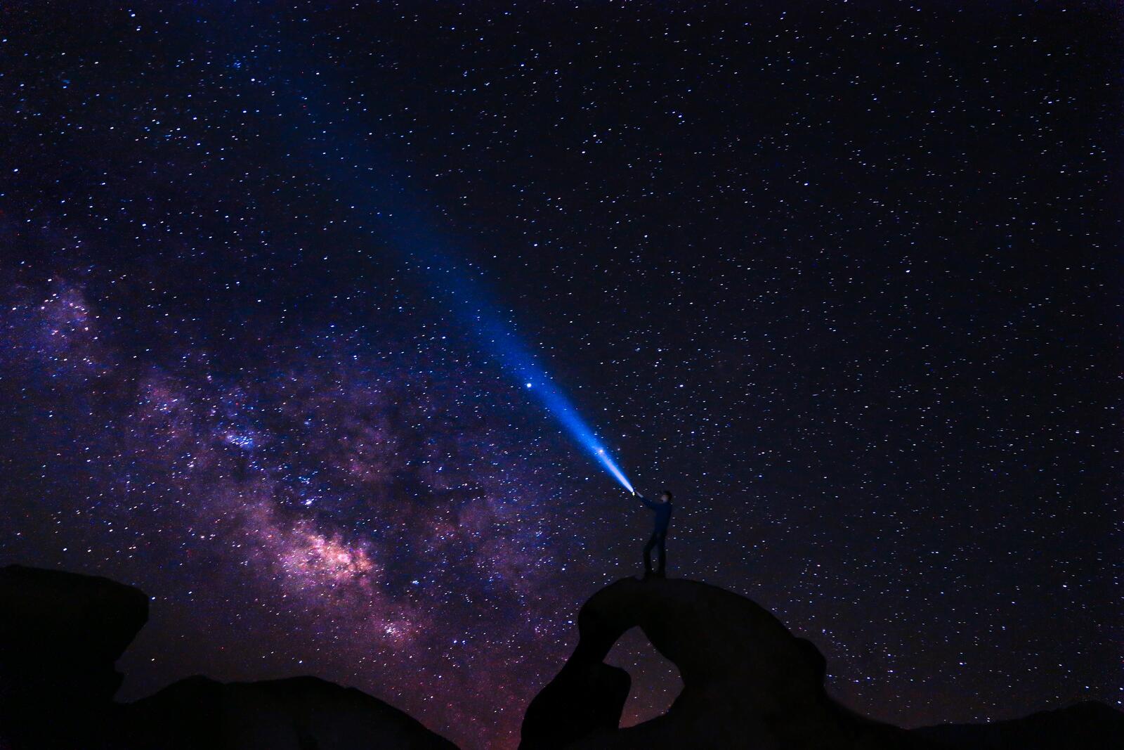 Бесплатное фото Парень на фоне ночного неба с фонарем