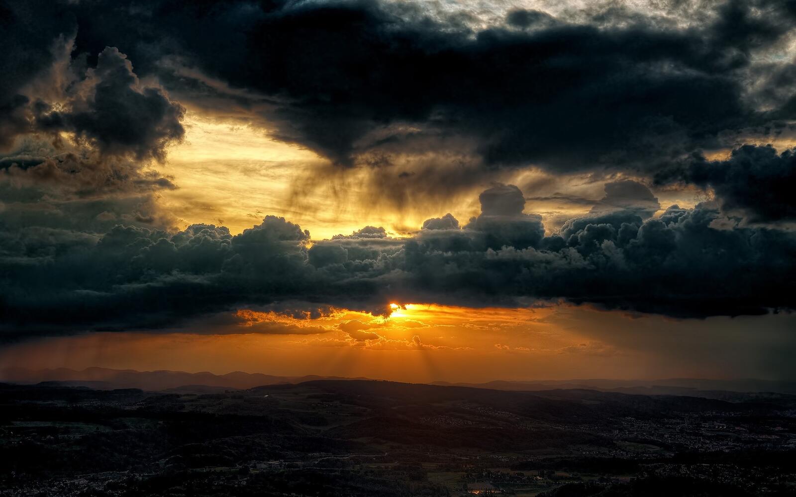 Бесплатное фото Солнце прячется за тяжелыми облаками