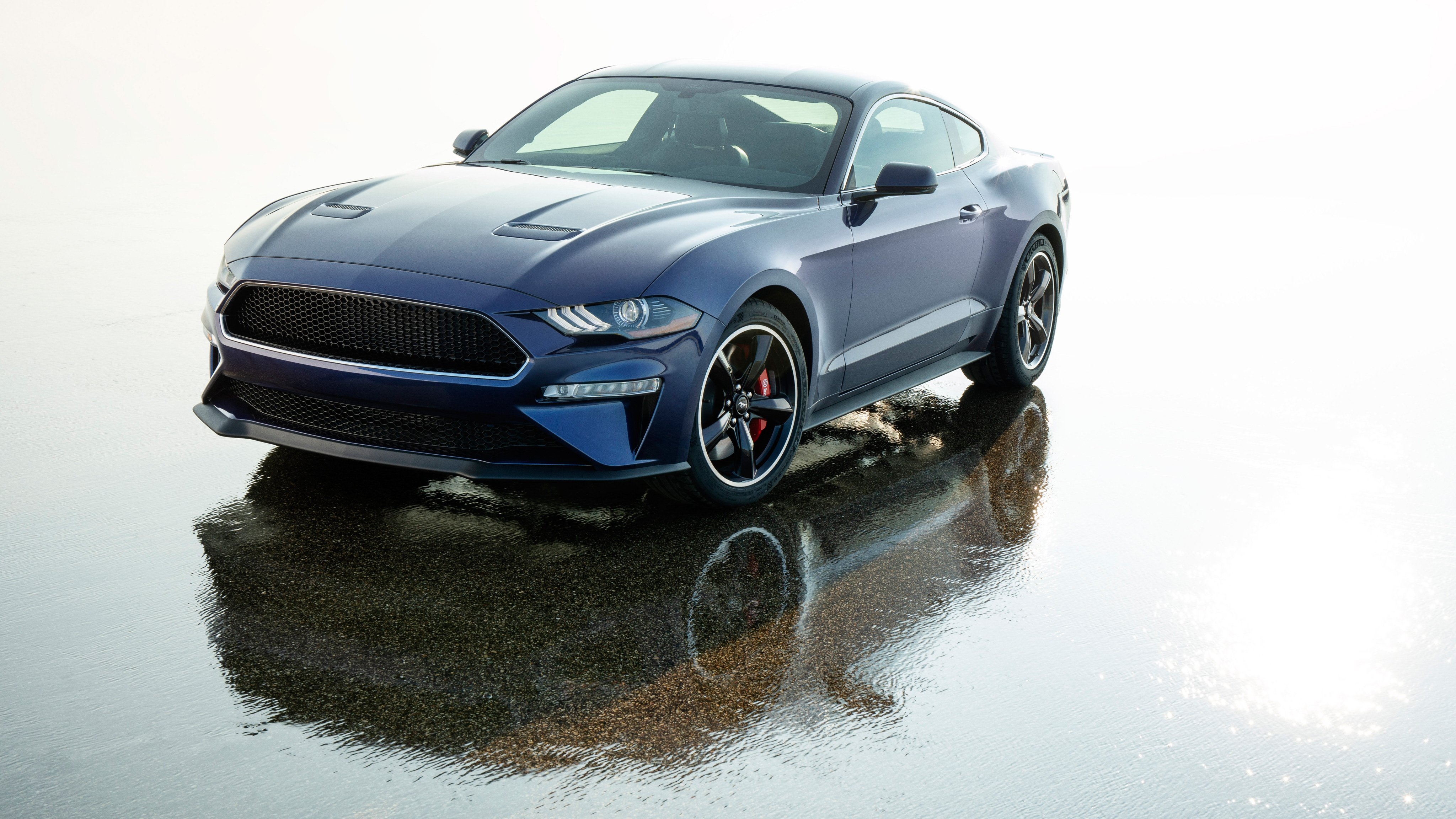 Синий Ford Mustang отражается в мокром асфальте