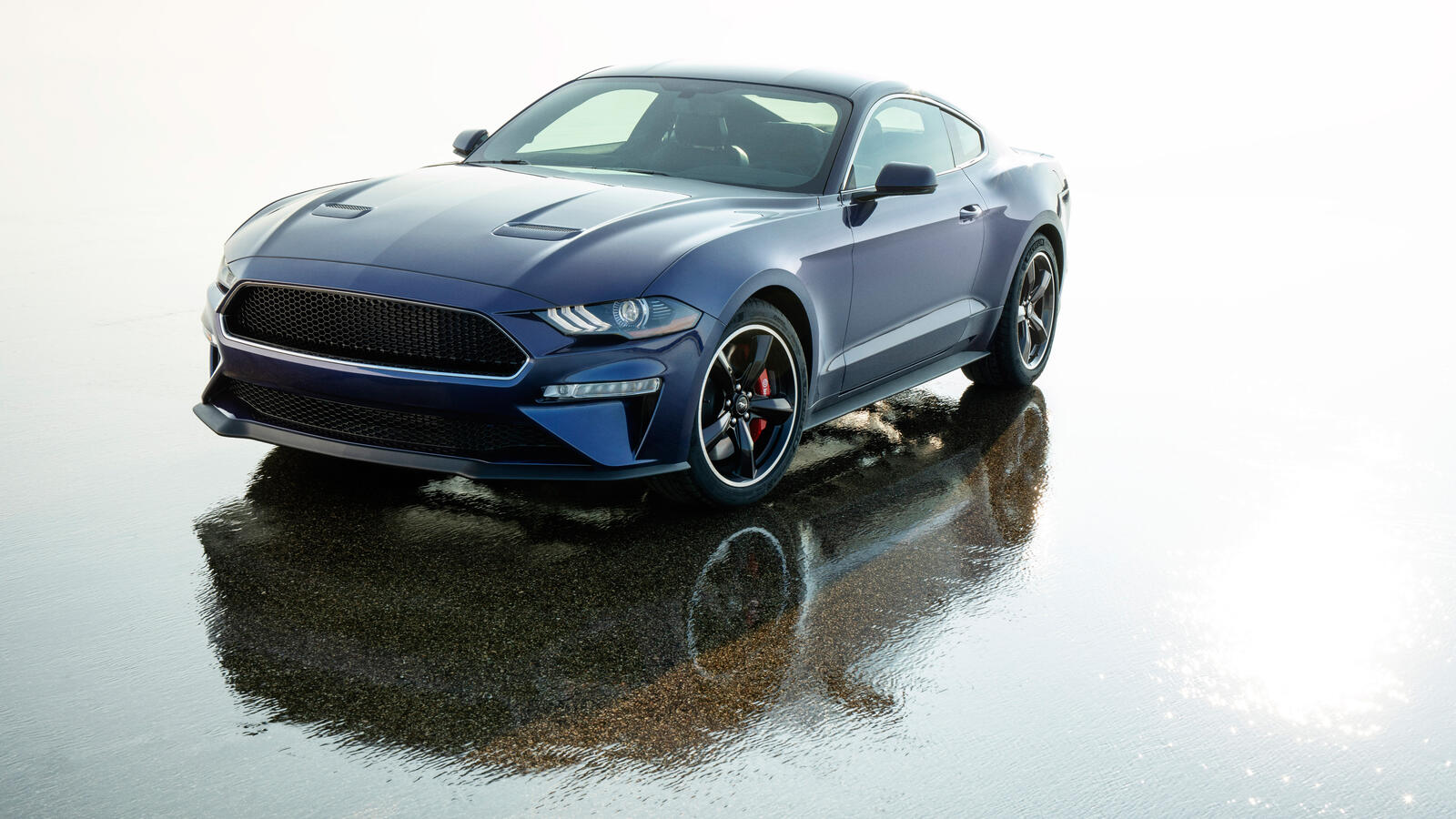 Бесплатное фото Синий Ford Mustang отражается в мокром асфальте