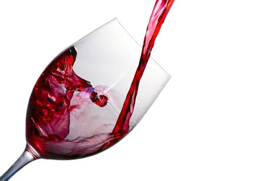 Red wine pours into a glass