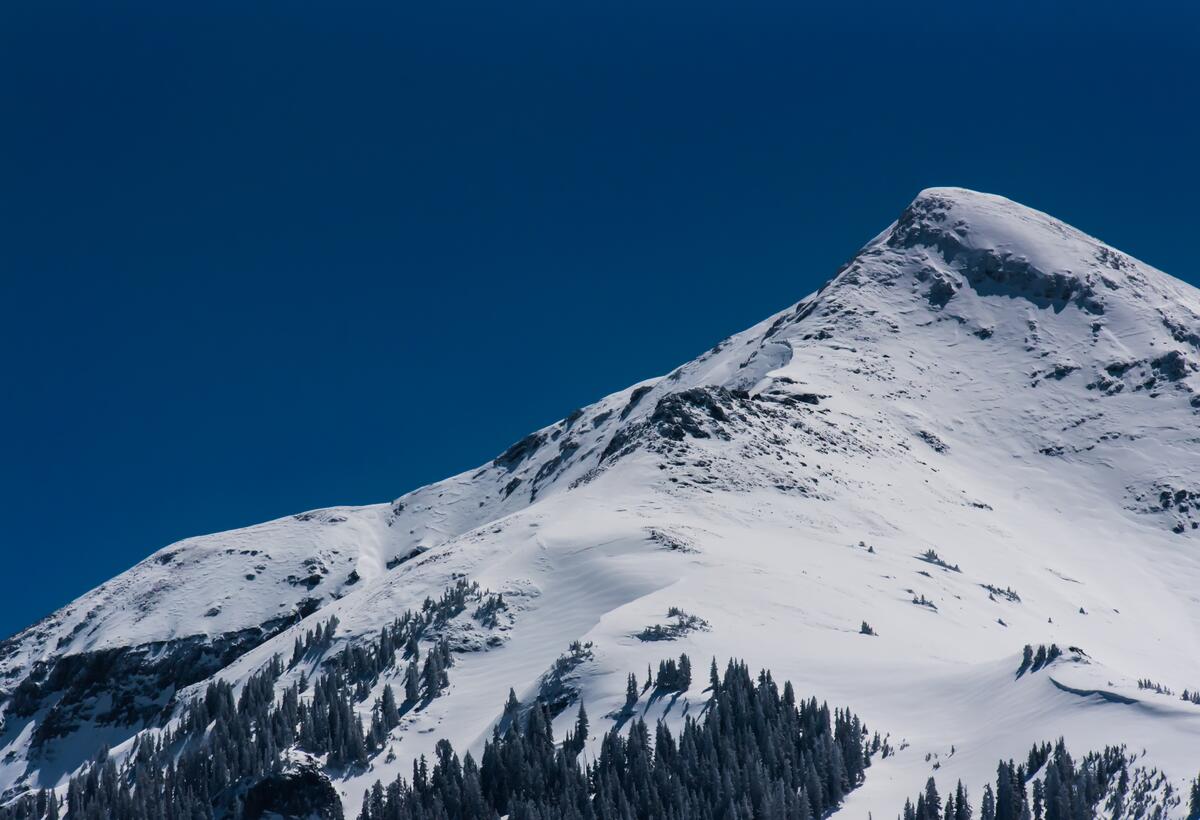 A large snowy mountain against a blue sky