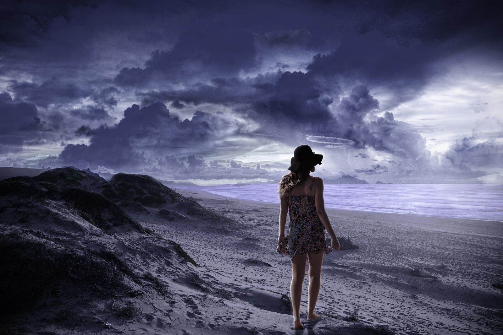 Бесплатное фото Девушка гуляет по пляжу в плохую погоду