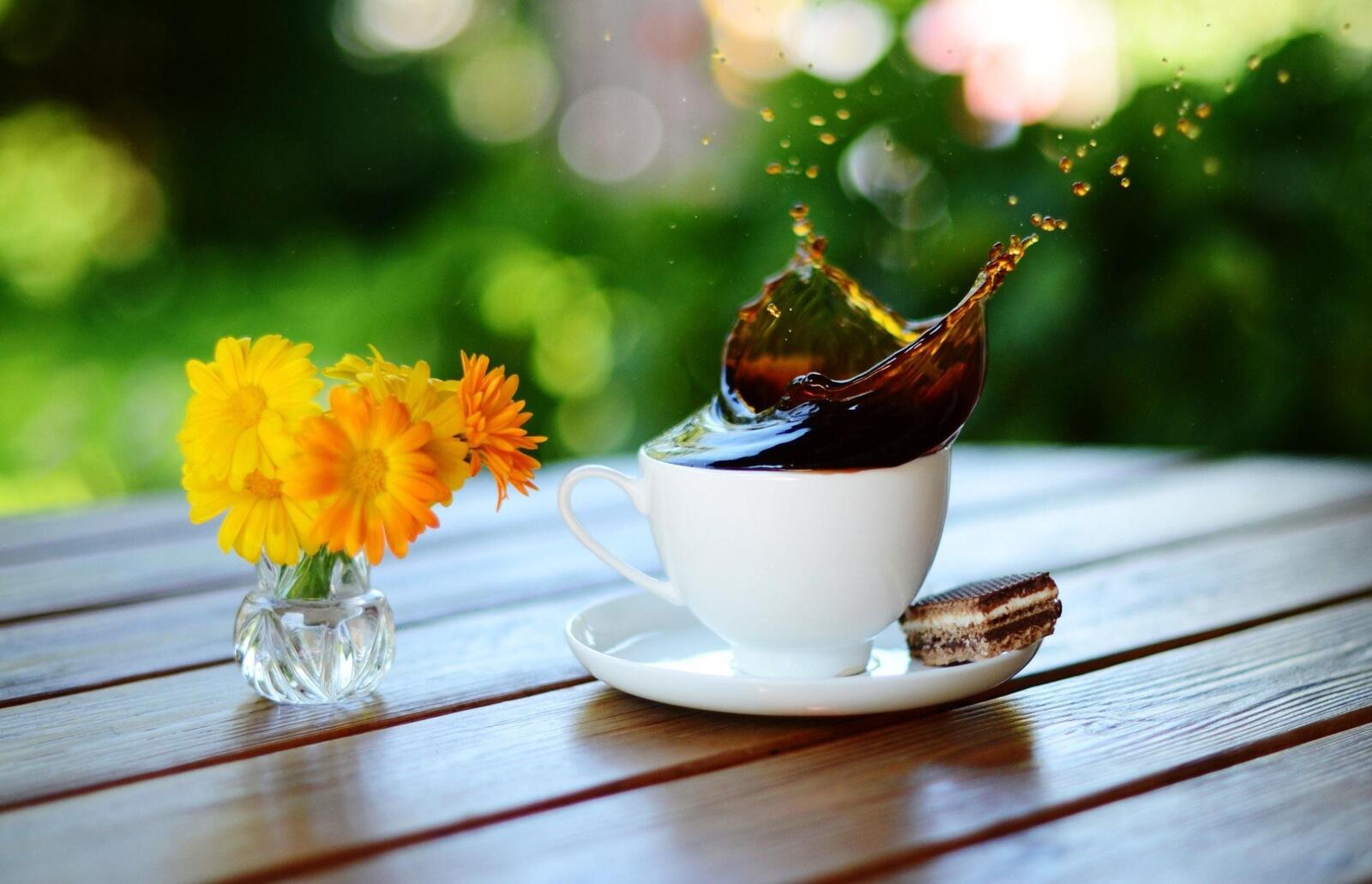 Бесплатное фото Всплеск кофе в белой чашке стоящей на столе