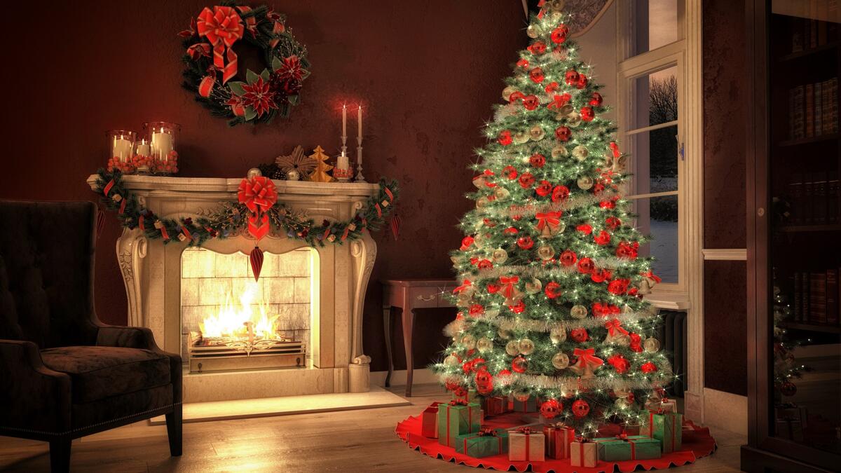 A lighted Christmas tree by the fireplace