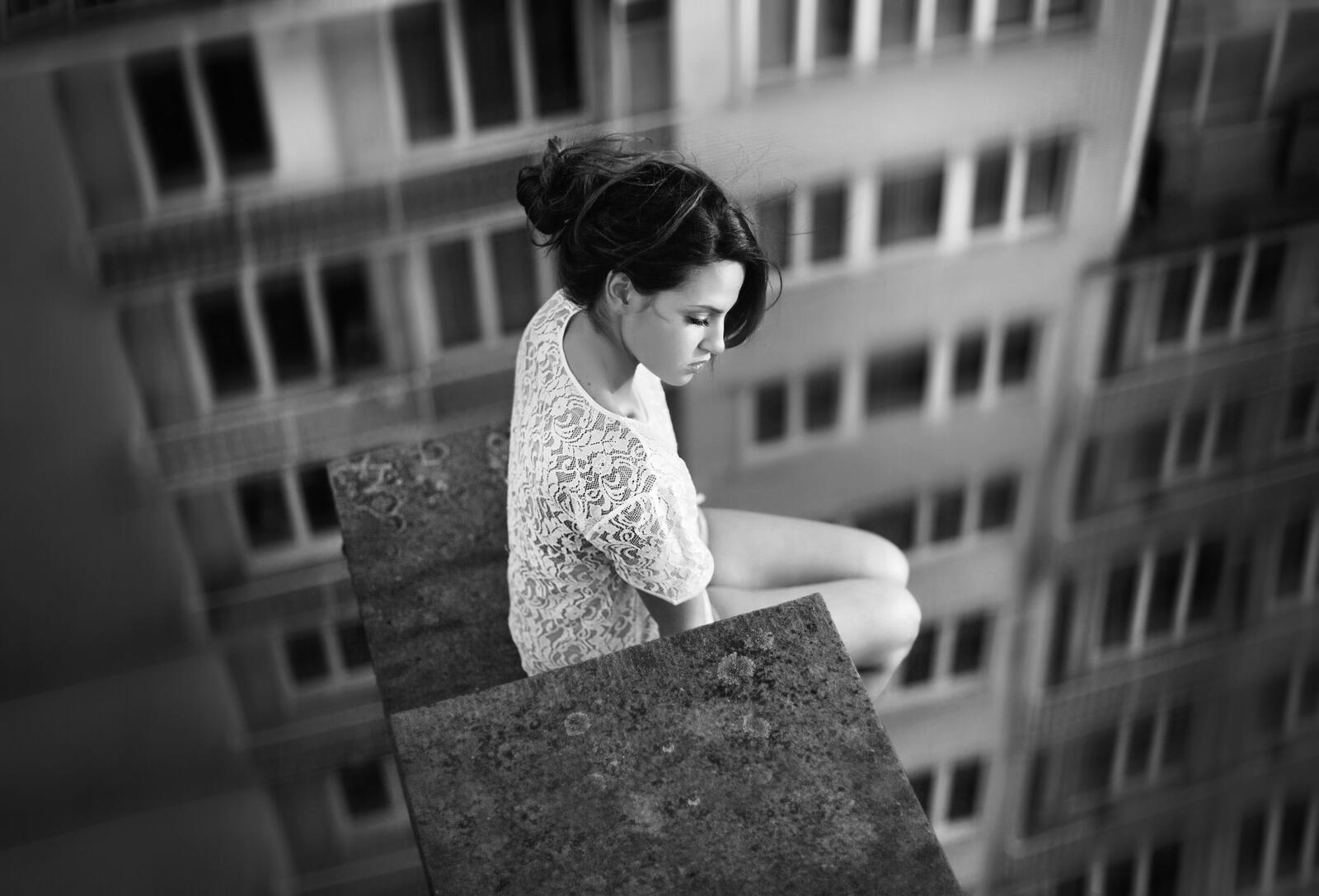 Бесплатное фото Девочка в белом платье сидит на краю крыши