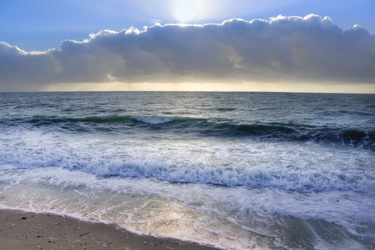 Морские волны в солнечный день на песочном пляже