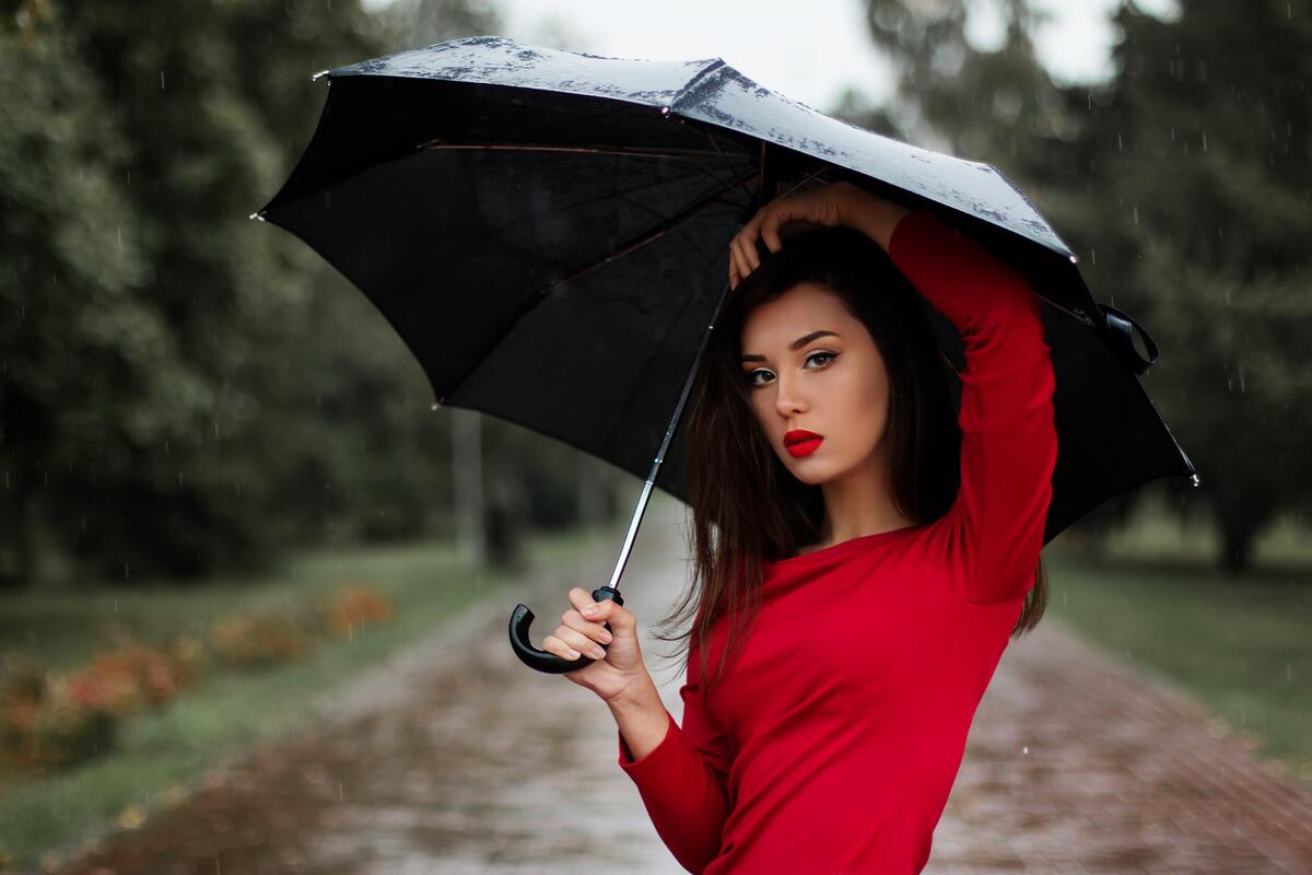 伞下的女孩穿着红色的裙子