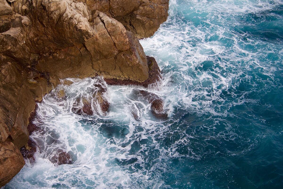 Волны разбиваются о скалистый берег моря