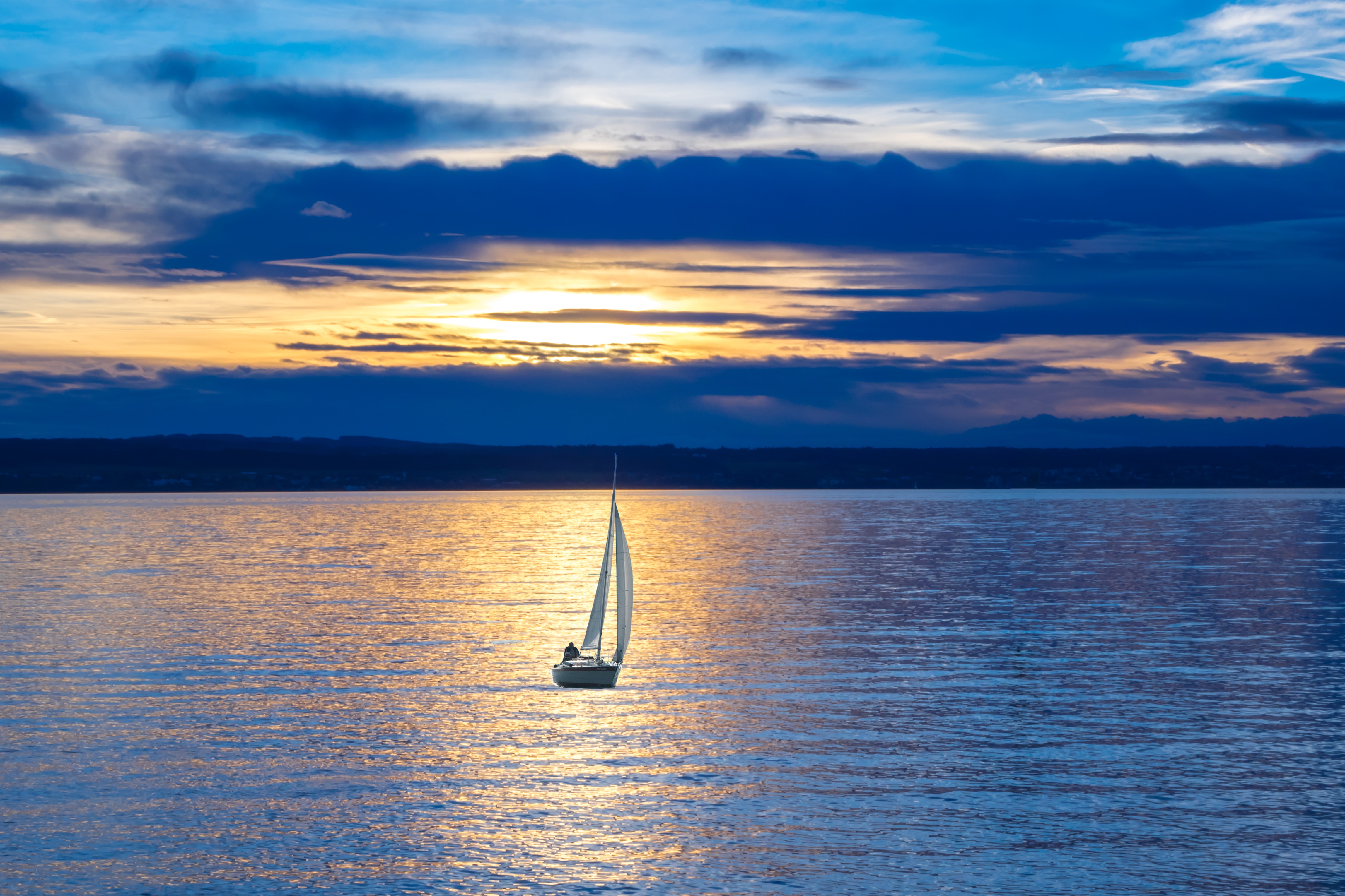 A lonely sailboat at sunset