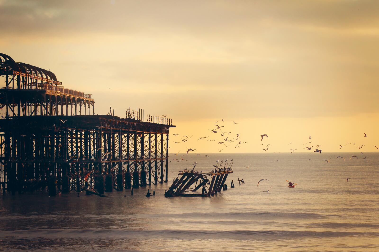 Бесплатное фото Разрушенный пирс на побережье моря