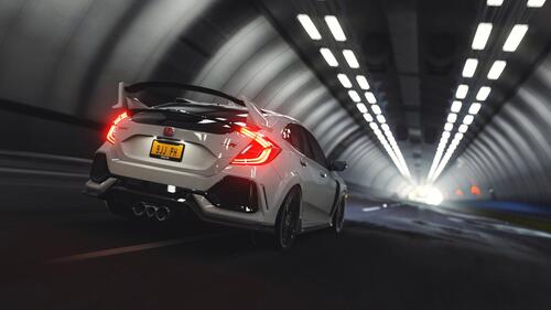 Белая Honda Civic Type R со спойлером едет в туннеле