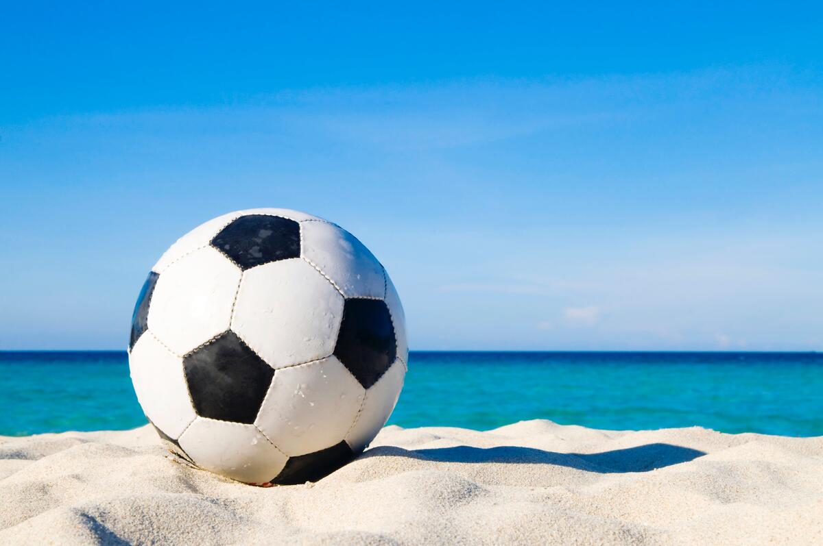 A soccer ball on a sandy beach