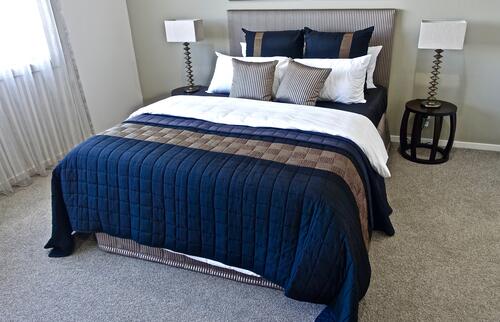 Красивая большая кровать в коттедже с синем пастельным бельем