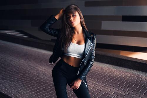 Beautiful brunette in sports bra and leather jacket