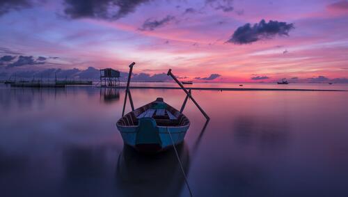 A wooden boat on the sea during sunset