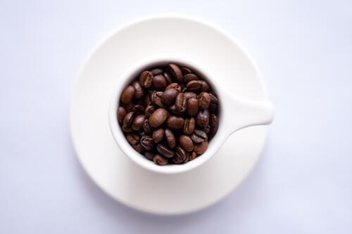 Чашка наполненная зернами кофе