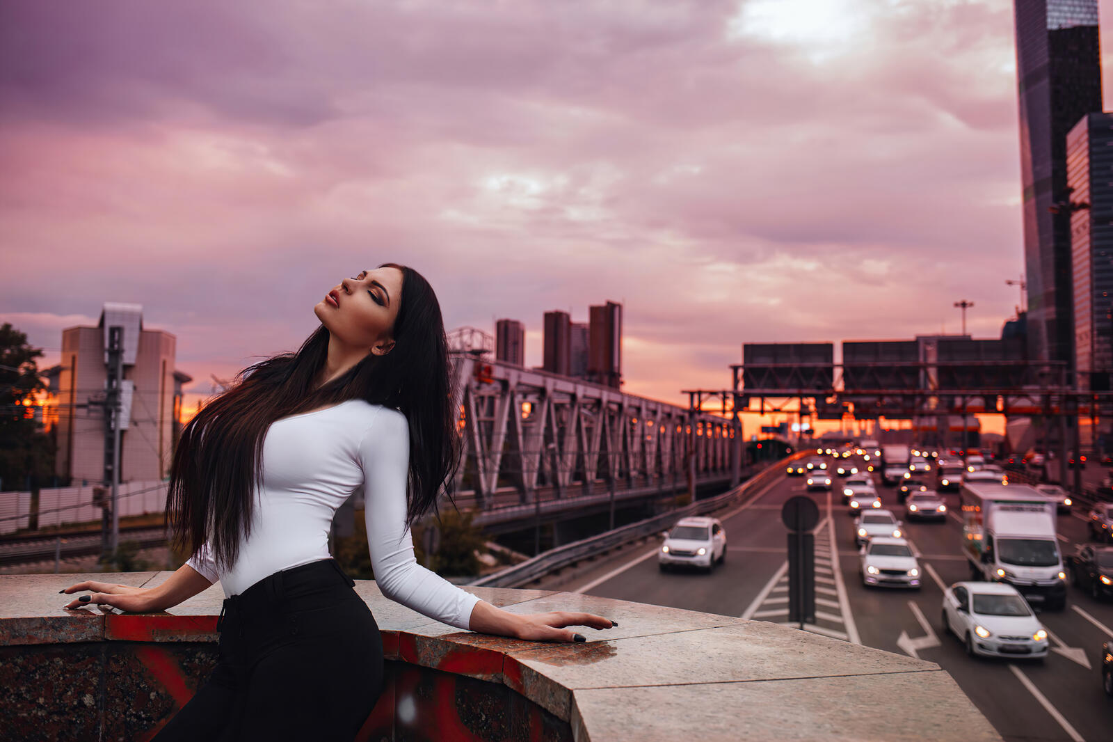 Free photo A brunette poses in front of an expressway