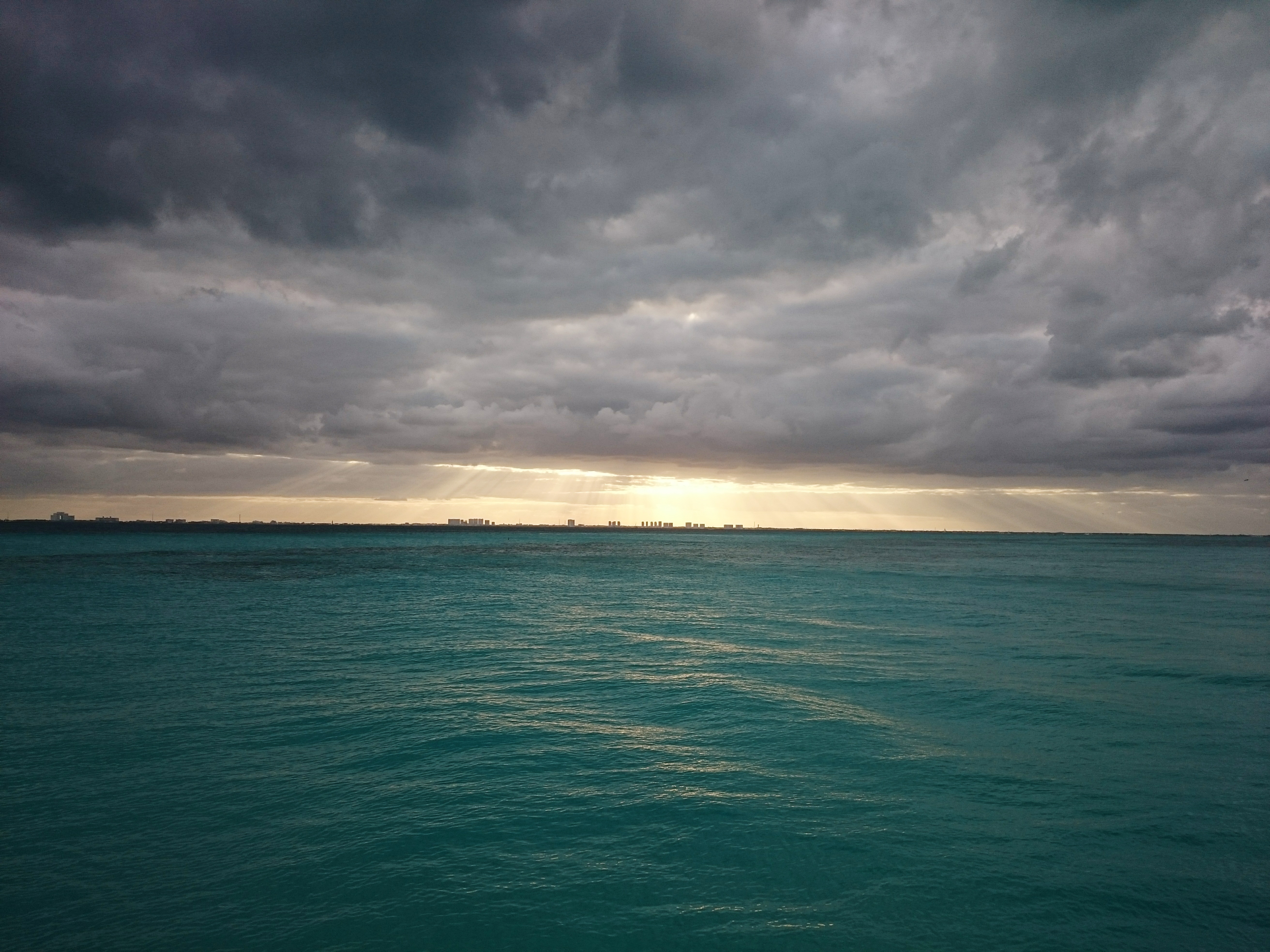 Free photo Beyond the horizon, sunlight breaks through the clouds