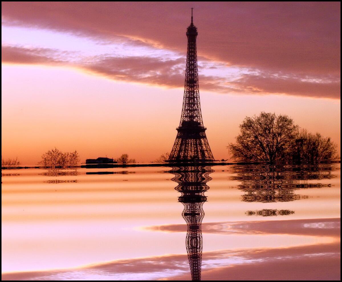 Eiffel Tower reflected in the water at sunset